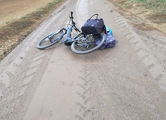 Fahrrad nach Sturz auf verschmutztem Wirtschaftsweg bei Umfahrung des Flughafentunnels 