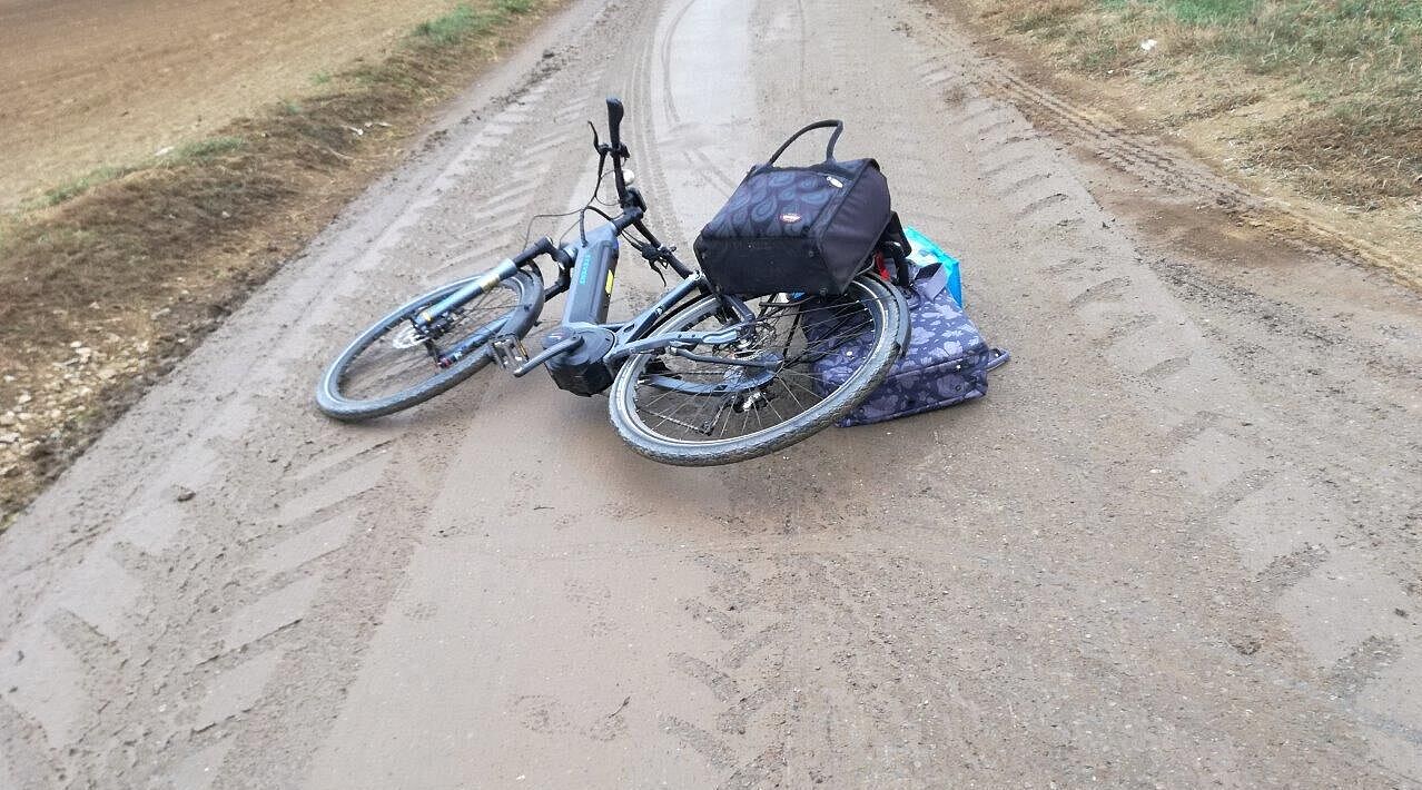 Fahrrad nach Sturz auf verschmutztem Wirtschaftsweg bei Umfahrung des Flughafentunnels 