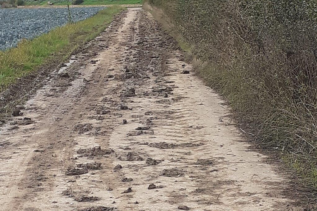 Verschmutzter Wirtschaftsweg auf der Umfahrung des Flughafentunnels unmittelbar nach der Feldarbeit