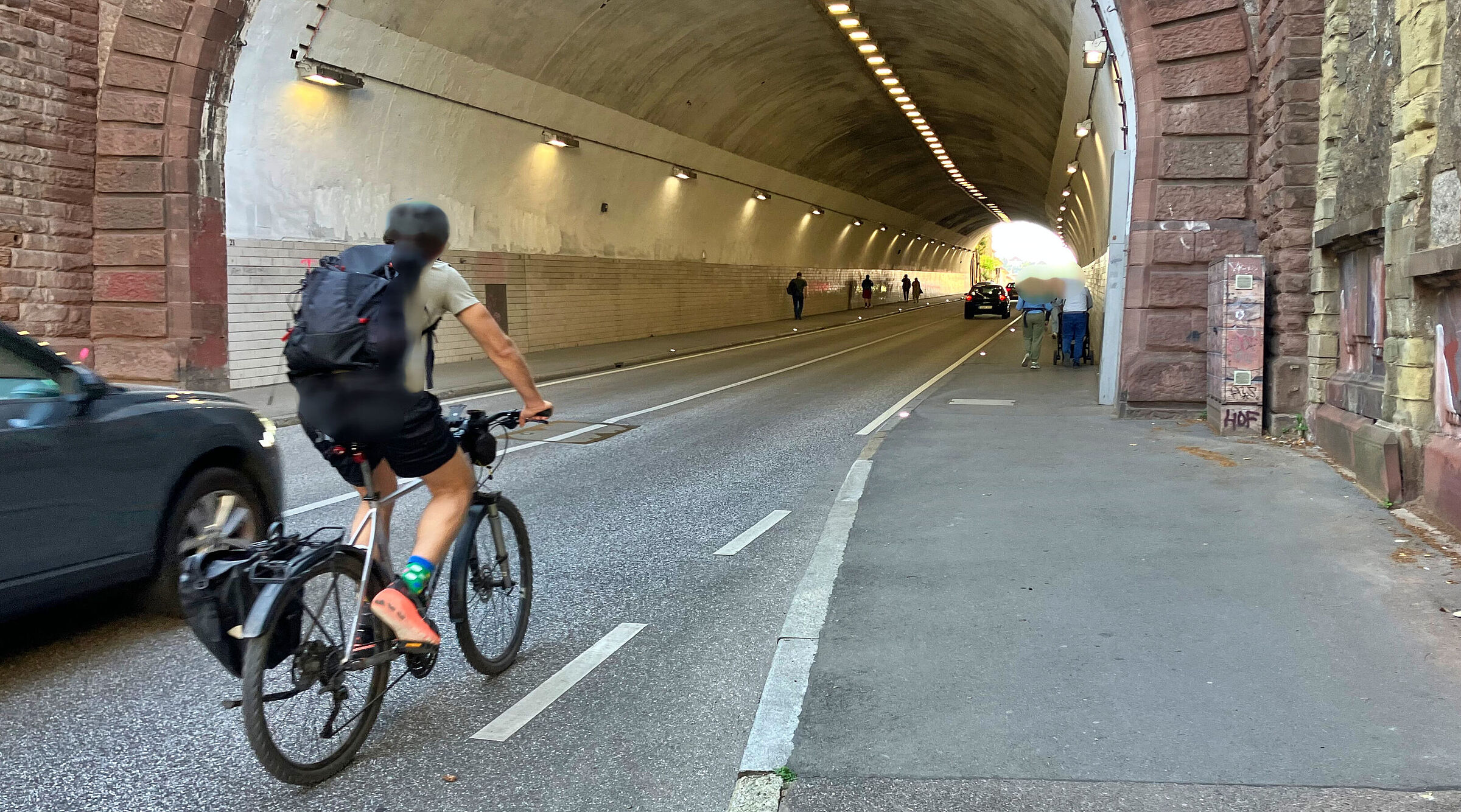Einfahrt in den Schwabtunnel: Auto- und Radfahrende kommen sich in die Quere, Fußgänger*innen brauchen den Gehweg für sich.
