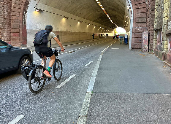 Einfahrt in den Schwabtunnel: Auto- und Radfahrende kommen sich in die Quere, Fußgänger*innen brauchen den Gehweg für sich.