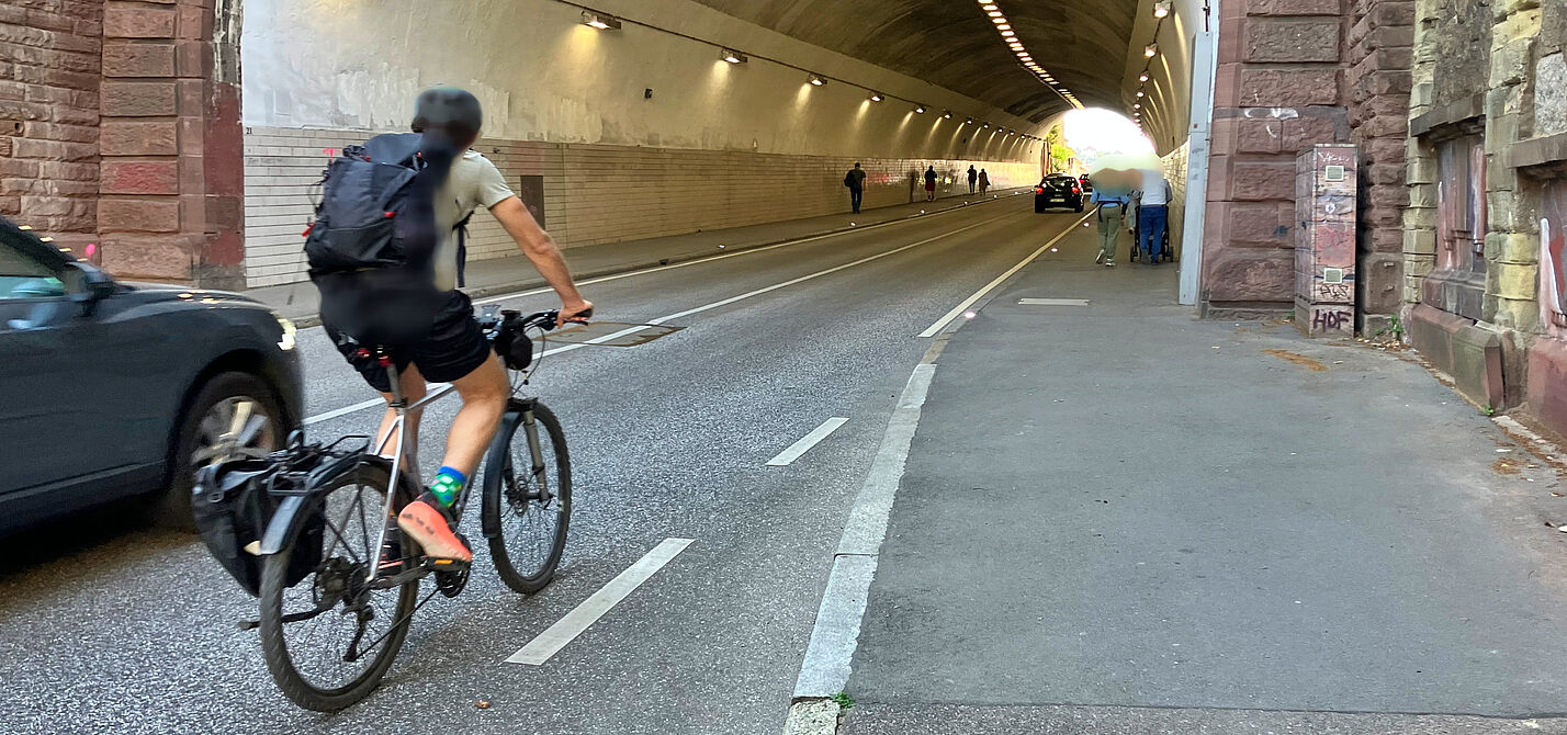 Einfahrt in den Schwabtunnel: Auto- und Radfahrende kommen sich in die Quere, Fußgänger*innen brauchen den Gehweg für sich.