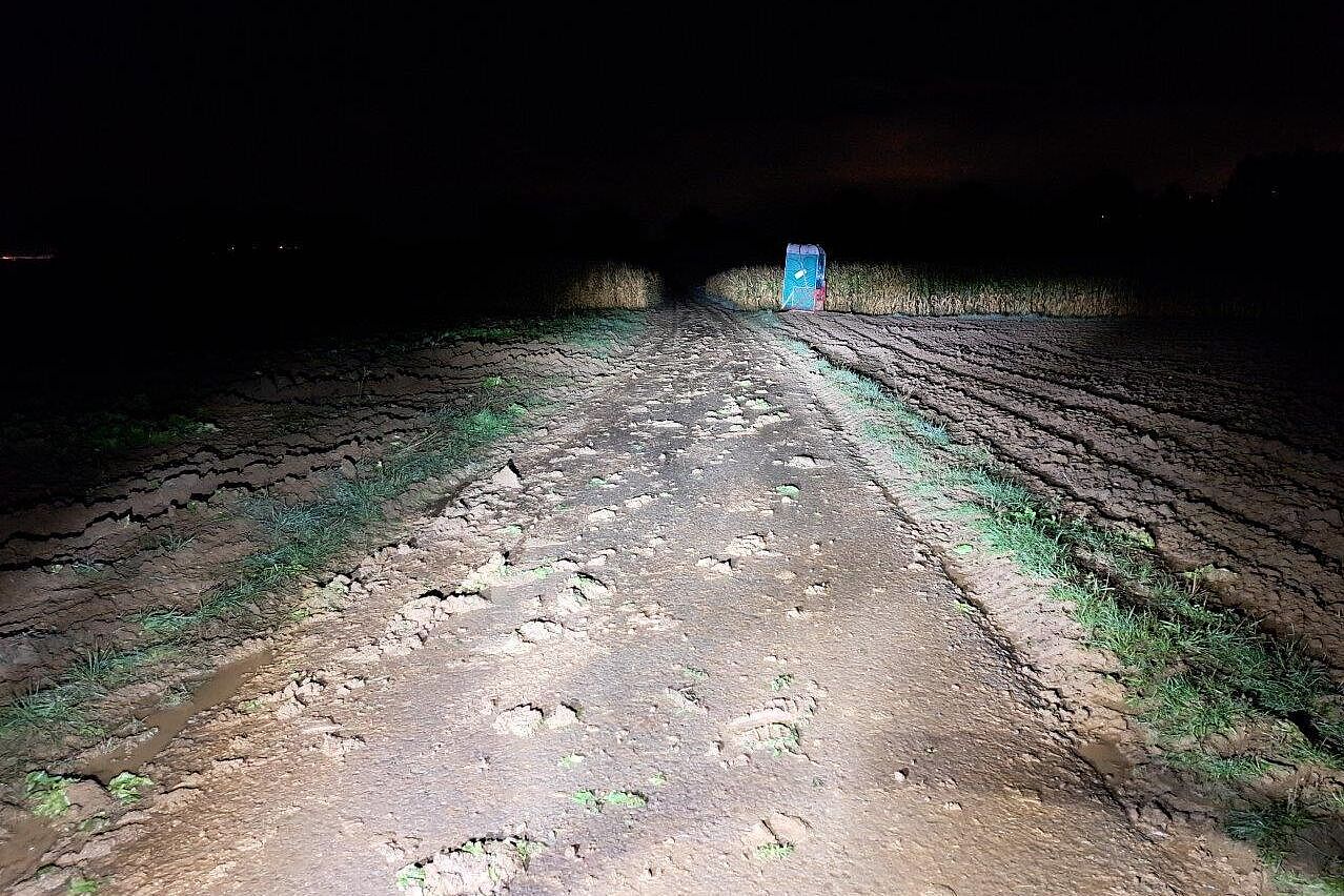 Verschmutzter Wirtschaftsweg auf der Umfahrung des Flughafentunnels bei Nacht